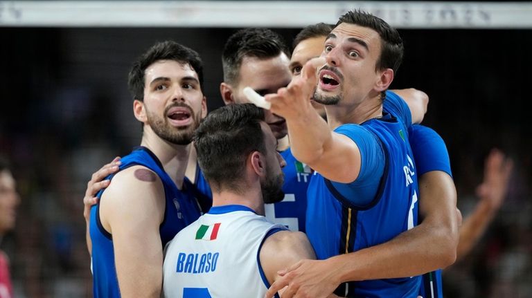 Italy's players celebrate after scoring a point during a men's...