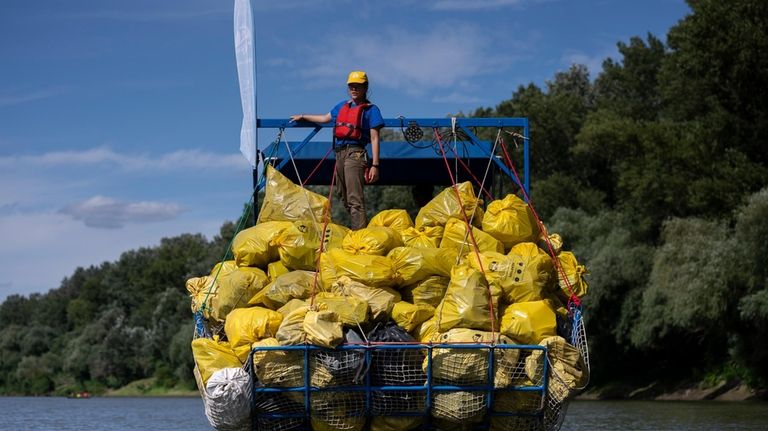 A volunteer stands on top of a pile of rubbish...