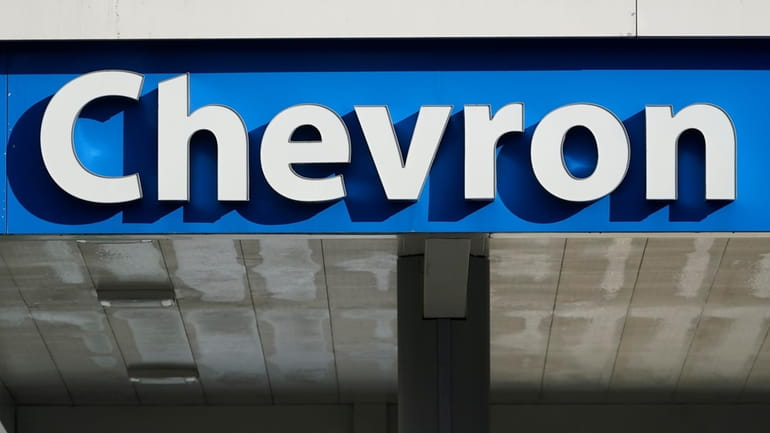 The Chevron logo is seen at a gas station in...