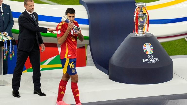 Spain's Rodri holds the player of the tournament trophy after...