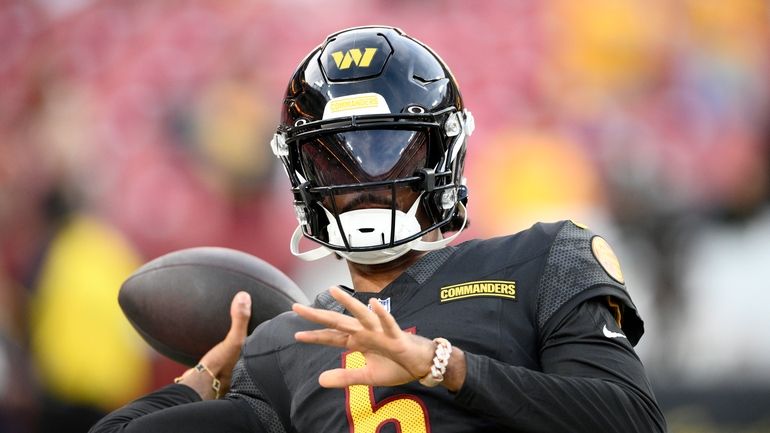 Washington Commanders quarterback Jayden Daniels warms up before a preseason...