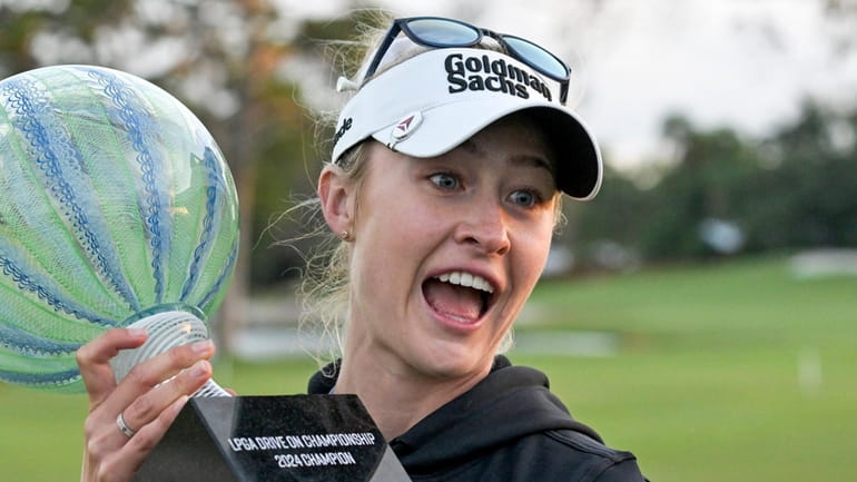 Nelly Korda holds the championship trophy after winning the LPGA...