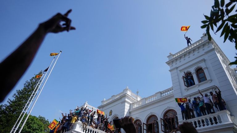 A Sri Lankan protester waves the national flag from the...