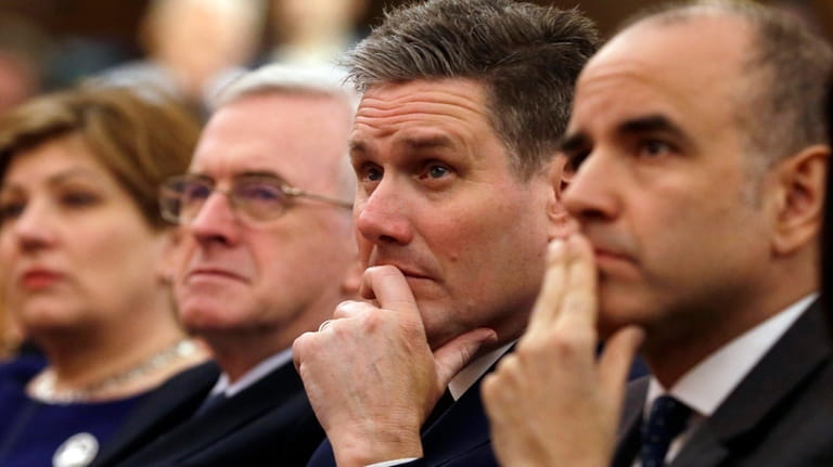 Keir Starmer, second right, of the Labour party listens to...