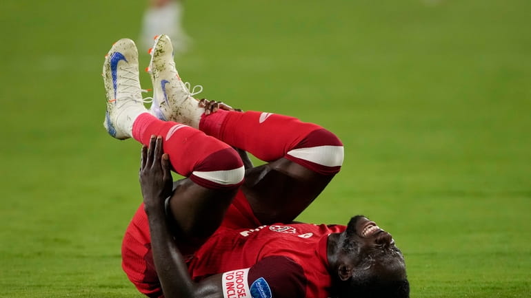 Canada's Alphonso Davies grimaces in pain during a Copa America...