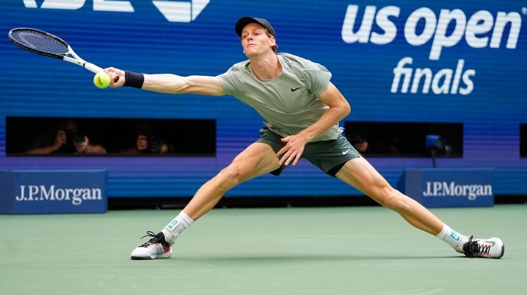 Jannik Sinner, of Italy, returns a shot to Taylor Fritz,...