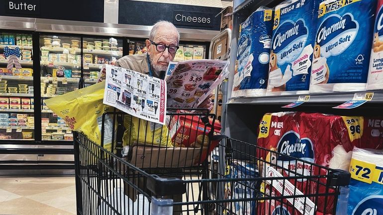 A shopper scans coupons in a grocery store in Washington,...