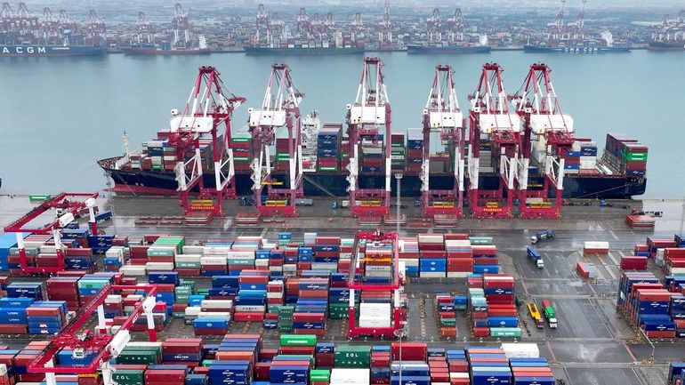 Cranes and transporters work at an automated container port in...