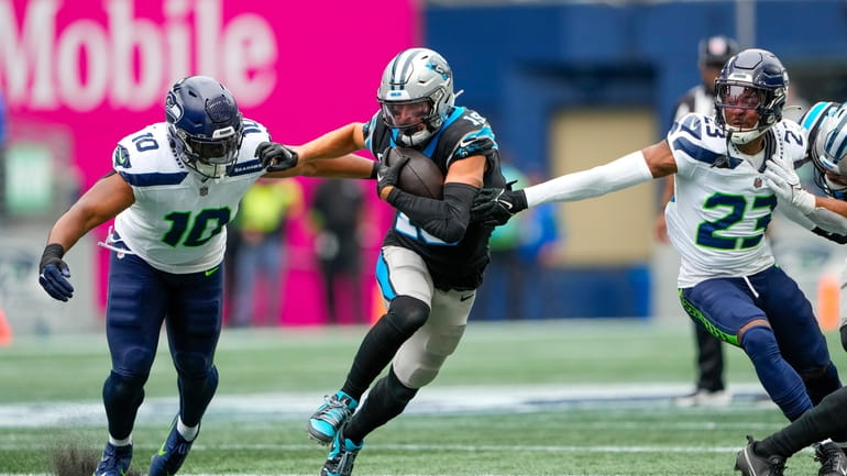 Carolina Panthers wide receiver Adam Thielen runs between Seattle Seahawks...