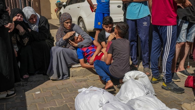 Palestinians mourn their relatives killed in the Israeli bombardment of...