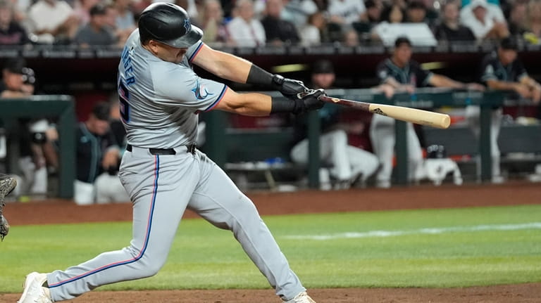 Miami Marlins' Jake Burger follows through on his swing for...