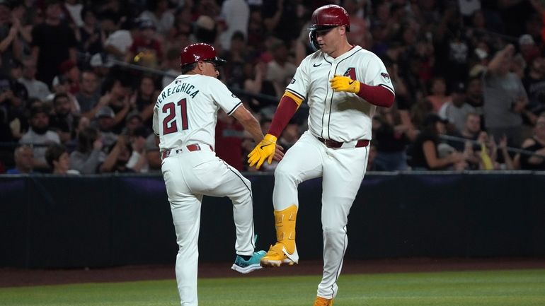 Arizona Diamondbacks' Joc Pederson celebrates with third base coach Tony...