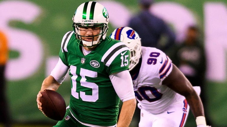 Jets quarterback Josh McCown scrambles away from Bills defensive end...