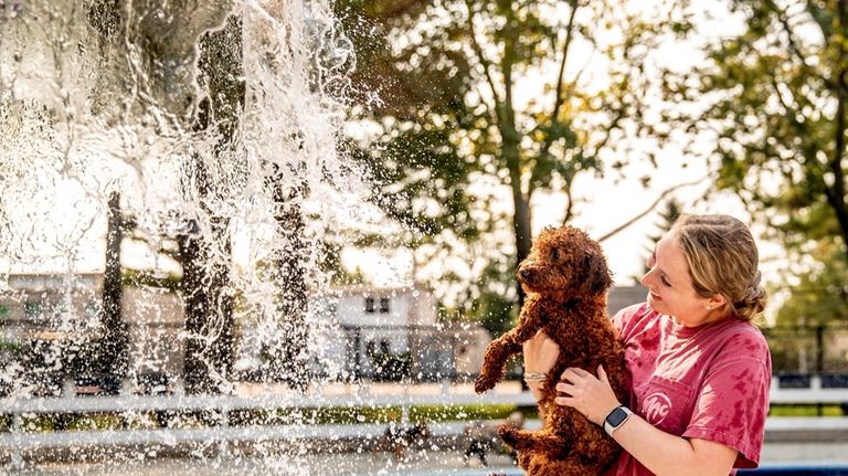 Jessica Oxer and her pup, Byron, of Syosset, splash around...