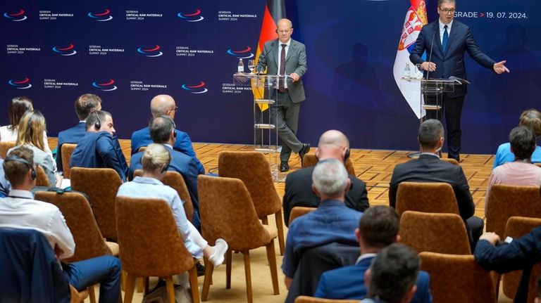 Serbian President Aleksandar Vucic, right, speaks during a press conference...