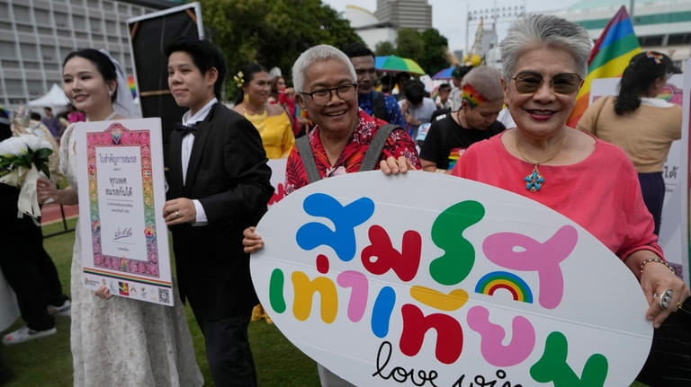 Participants hold posters celebrating equality in marriage during the Pride...