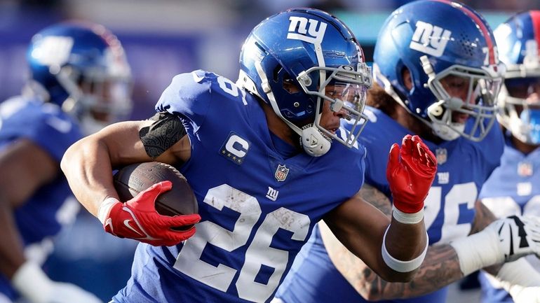 Saquon Barkley #26 of the New York Giants runs the...