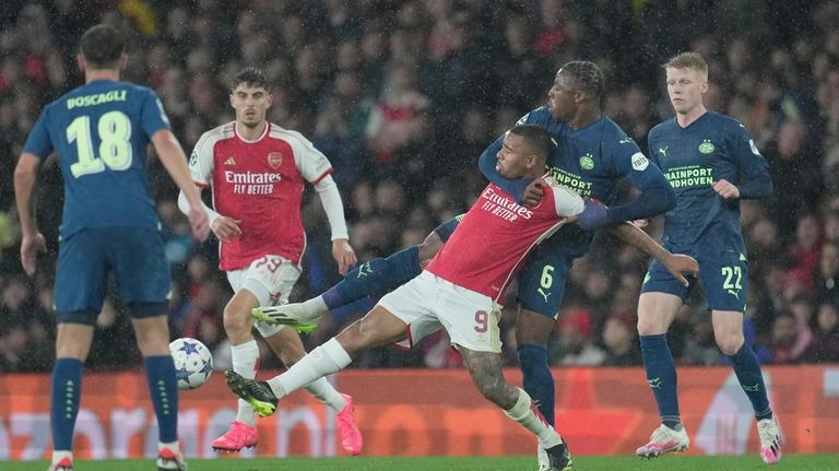 Arsenal's Gabriel Jesus, center, and PSV's Armel Bella-Kotchap vie for...