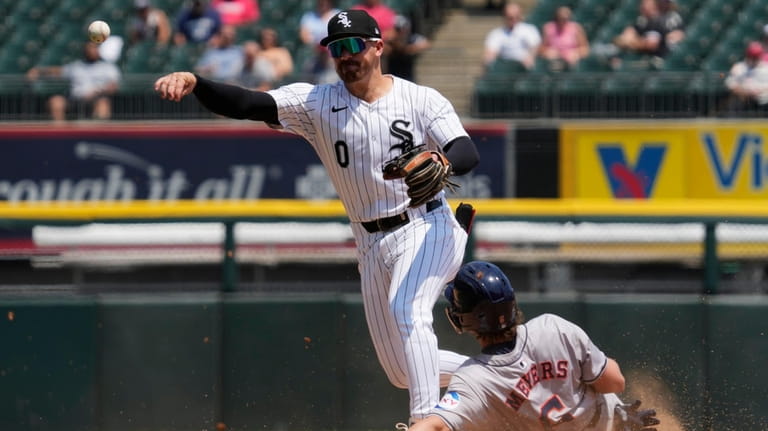 Chicago White Sox second baseman Danny Mendick, left, throws out...