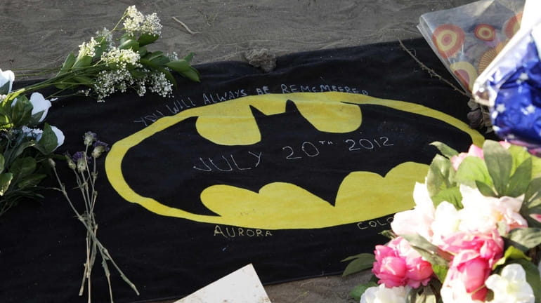 A Batman logo is shown at the memorial to victims...