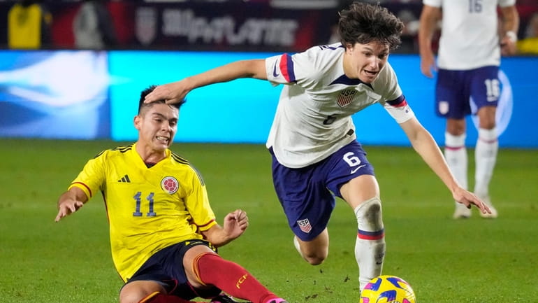 FILE _ United States' Paxten Aaronson, right, dribbles past Colombia's...