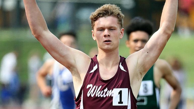 Whitman's John Poplawski signals victory after finishing first in the...