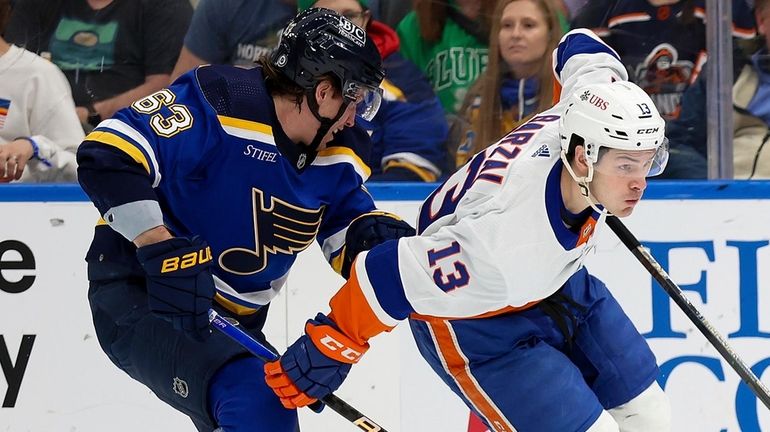 The Islanders' Mathew Barzal controls the puck while under pressure from...