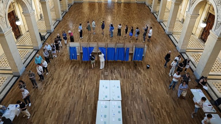 Voters wait at a polling station to vote in the...