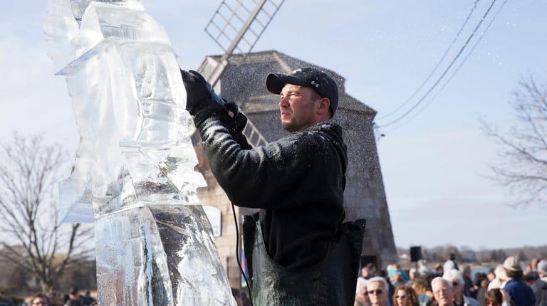 Hundreds of spectators watch an ice carving demo on the...