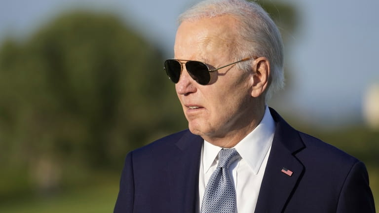 President Joe Biden answers a question as he watches a...