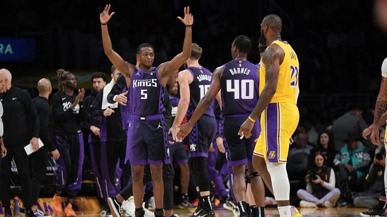 Sacramento Kings guard De'Aaron Fox, left, celebrates with forward Harrison...