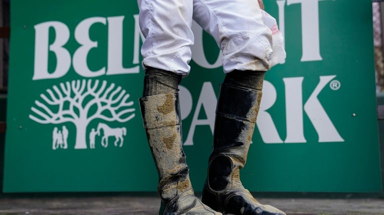 A jockey's boots are caked in mud after an early...