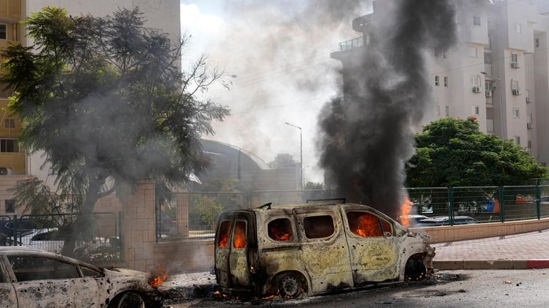 Cars are on fire after they were hit by rockets...