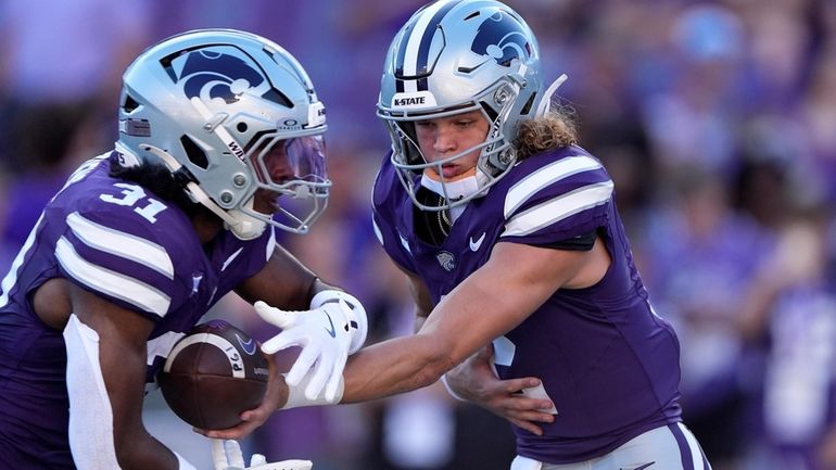 Kansas State quarterback Avery Johnson, right, hands off to running...