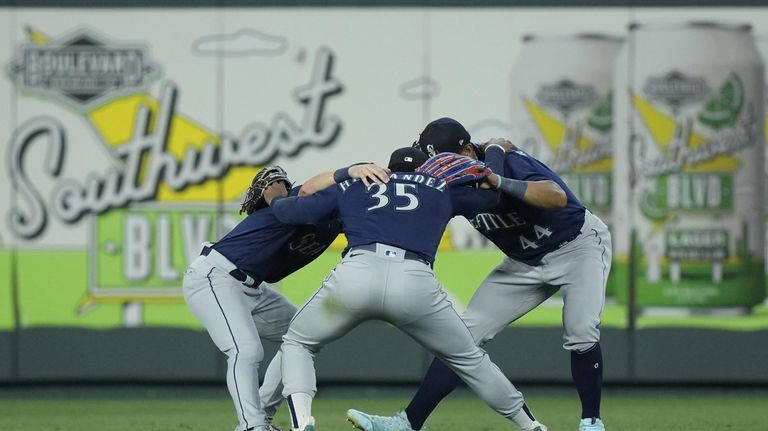 Seattle Mariners outfielders celebrate after their baseball game against the...