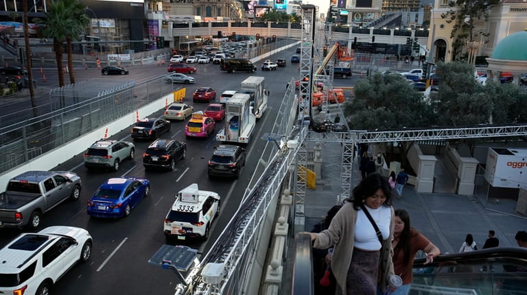 Pedestrians take an escalator along the Las Vegas Strip beside...