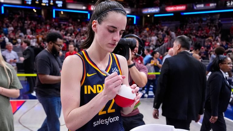 Indiana Fever guard Caitlin Clark (22) signs mini basketballs for...