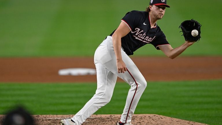 Washington Nationals starting pitcher Jake Irvin fields a louder by...