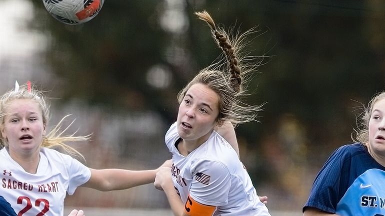 Sacred Heart's Mae Mullen heads in the winning goal in...