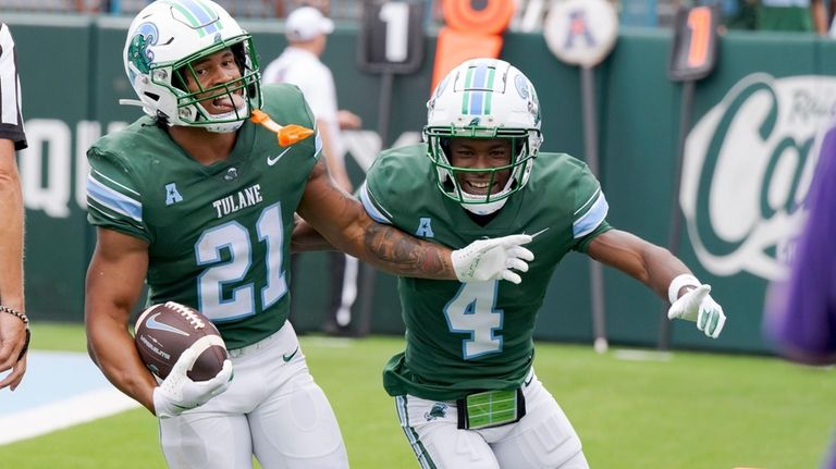 Tulane running back Makhi Hughes (21) celebrates a touchdown with...