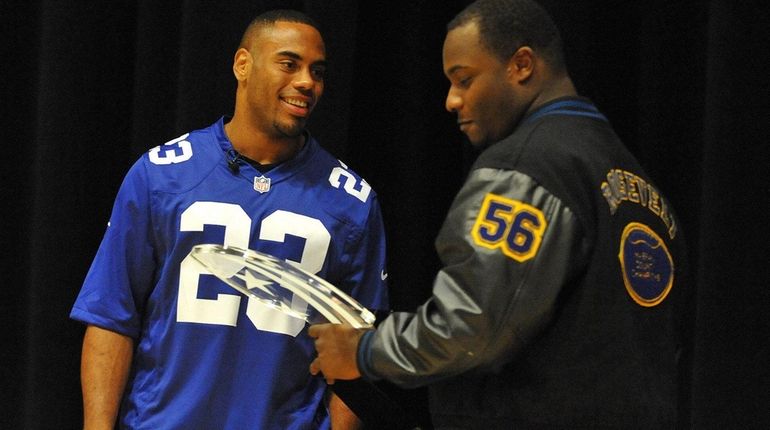 New York Giants running back Rashad Jennings, left, presents Roosevelt...