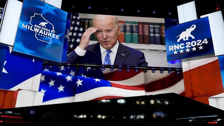 An image of President Joe Biden is projected on a...