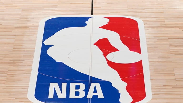 The NBA logo in shown on a basketball court in...
