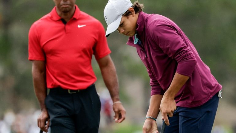 FILE -Tiger Woods, left, watches his son Charlie, right, putt...