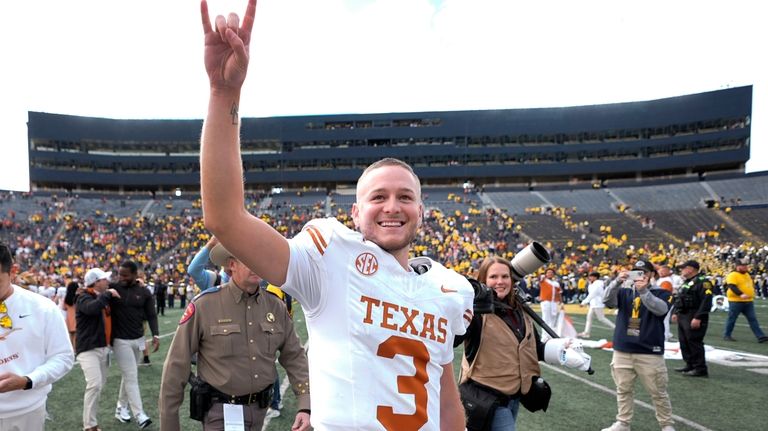 Texas quarterback Quinn Ewers smiles while acknowledging the crowd after...