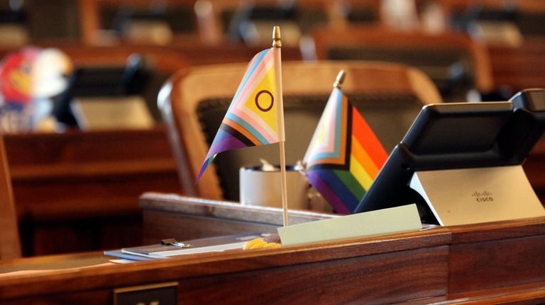 Small flags promoting transgender rights sit on the Kansas House...