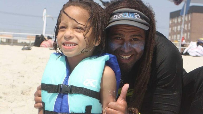 After completing his first surfing lesson, Long Beach student Isaiah...