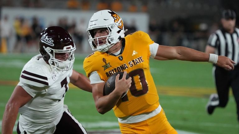 Arizona State quarterback Sam Leavitt (10), front right, scores a...