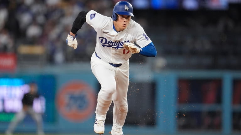 Los Angeles Dodgers' Shohei Ohtani heads to third base and...