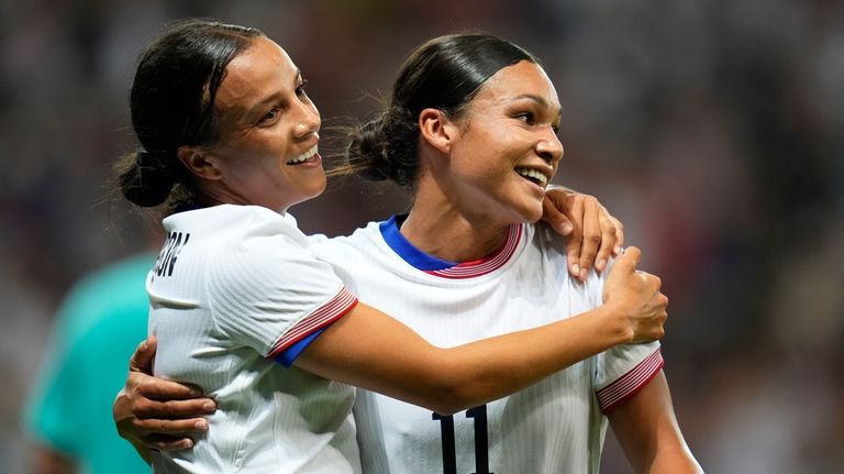 United States' Mallory Swanson, left, reacts with teammate Sophia Smith...